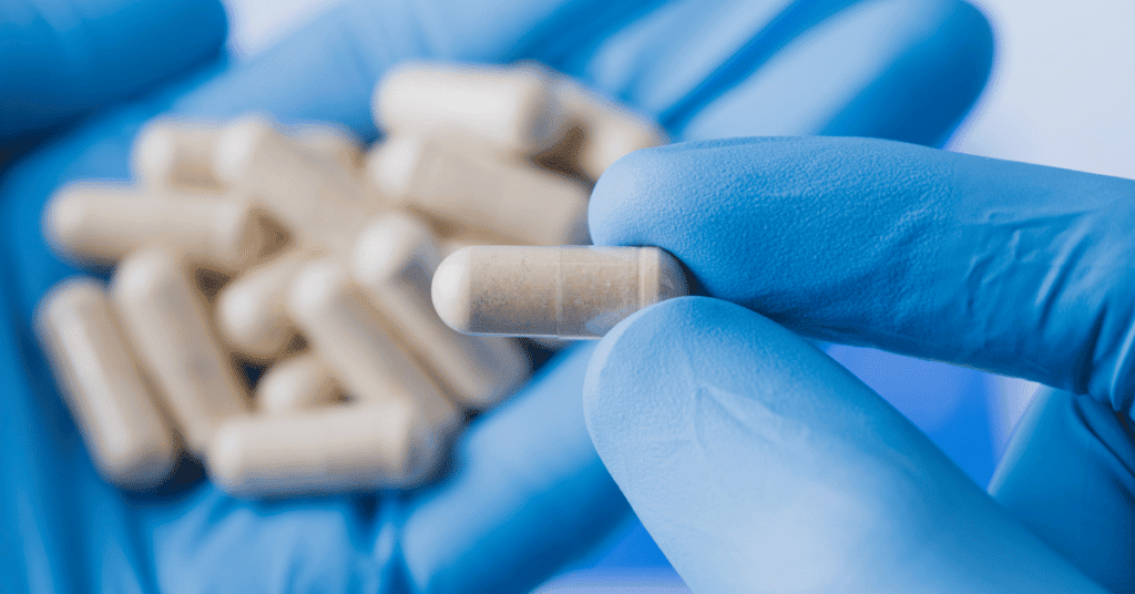 Close-up picture of a person holding a capsule supplement"