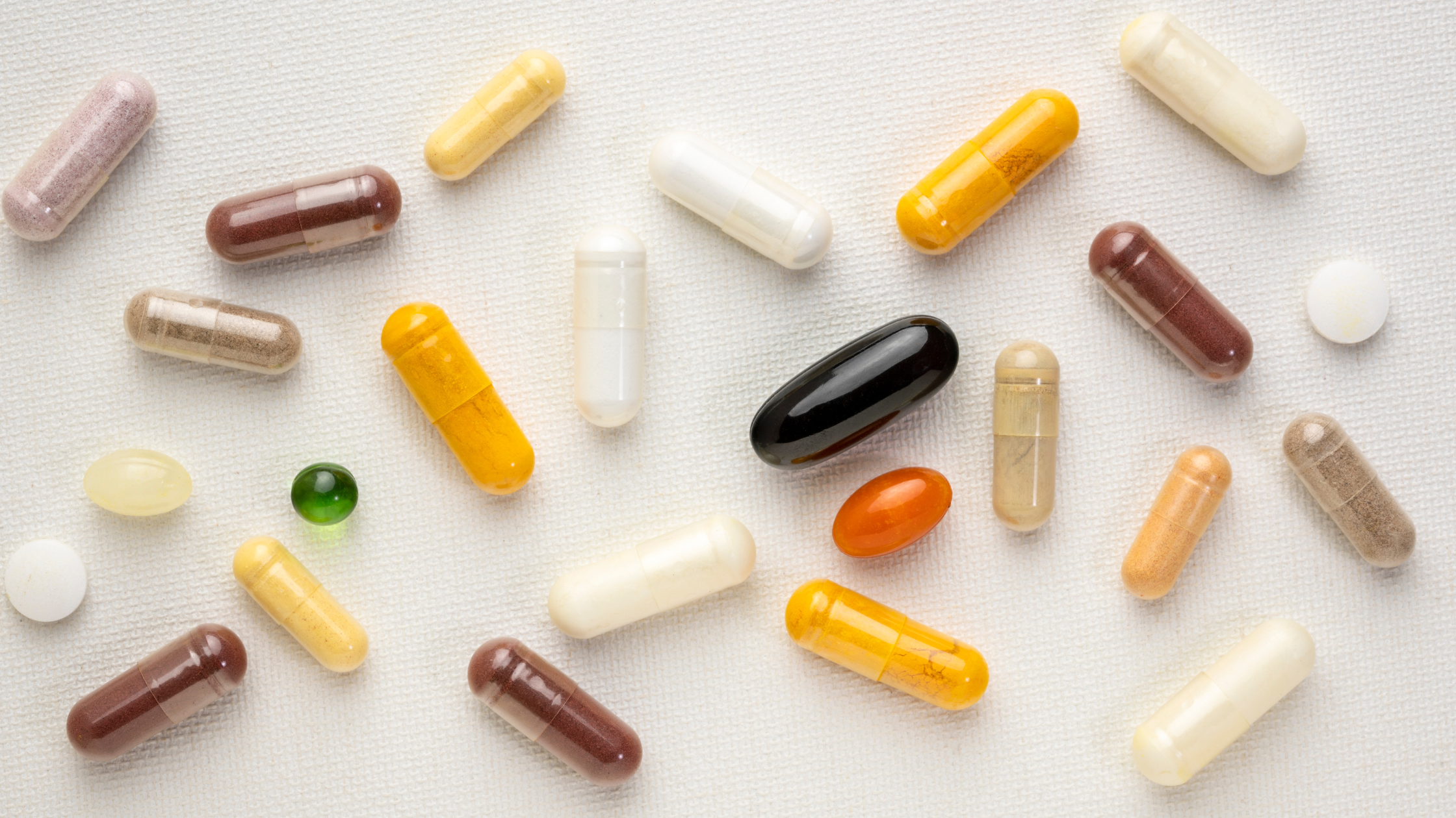 Assorted colorful capsules and tablets on a white surface