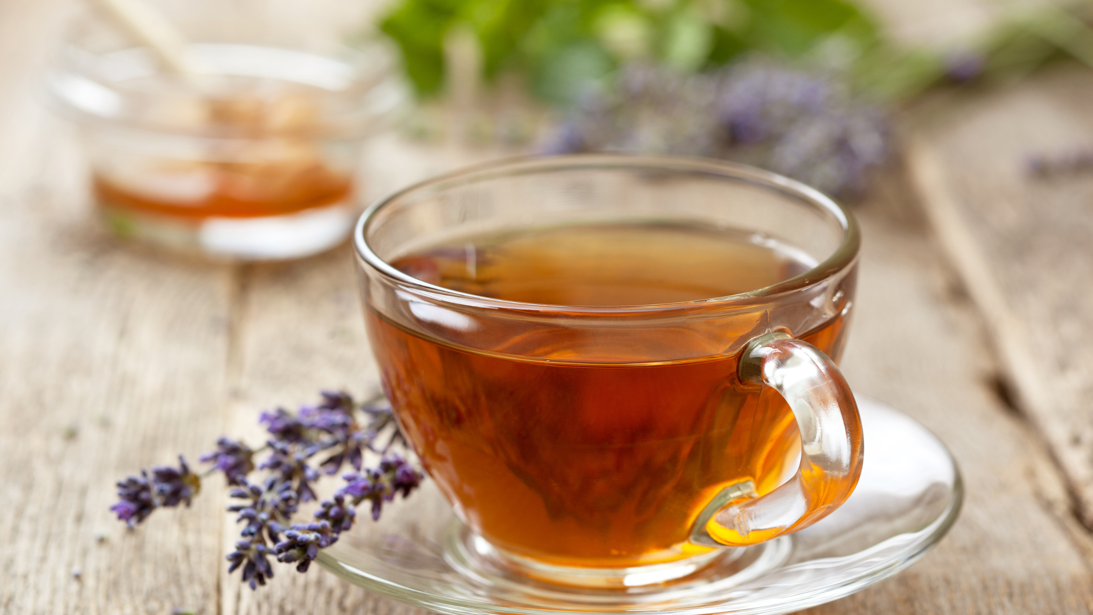 Clear glass cup of herbal tea with lavender sprigs