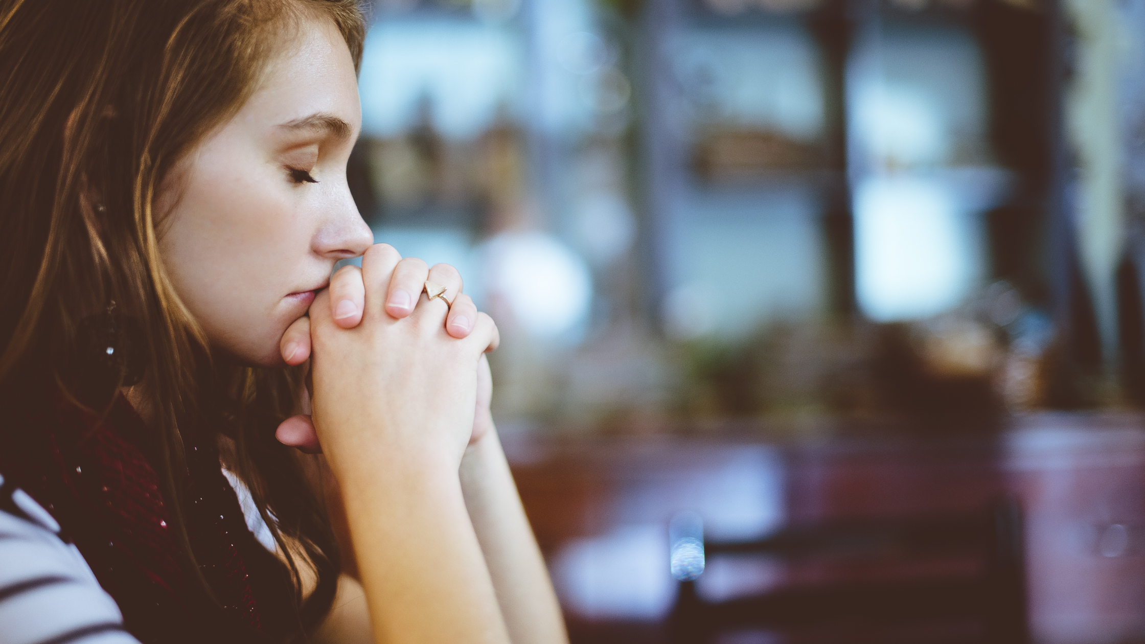 Woman with closed eyes in a thoughtful prayer pose