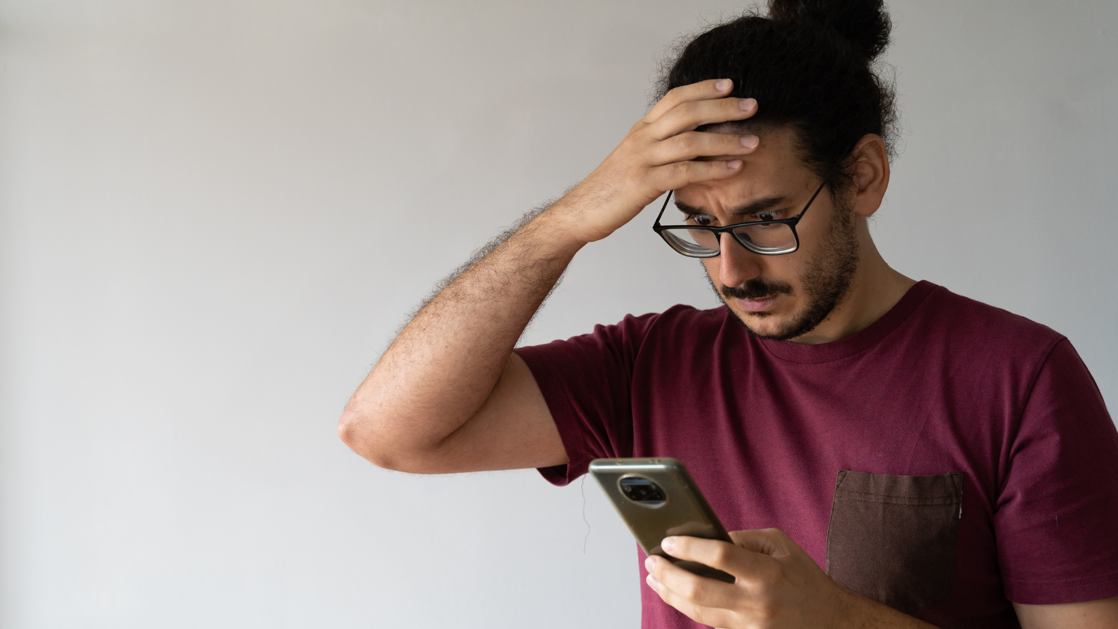 Man looking worried while checking smartphone