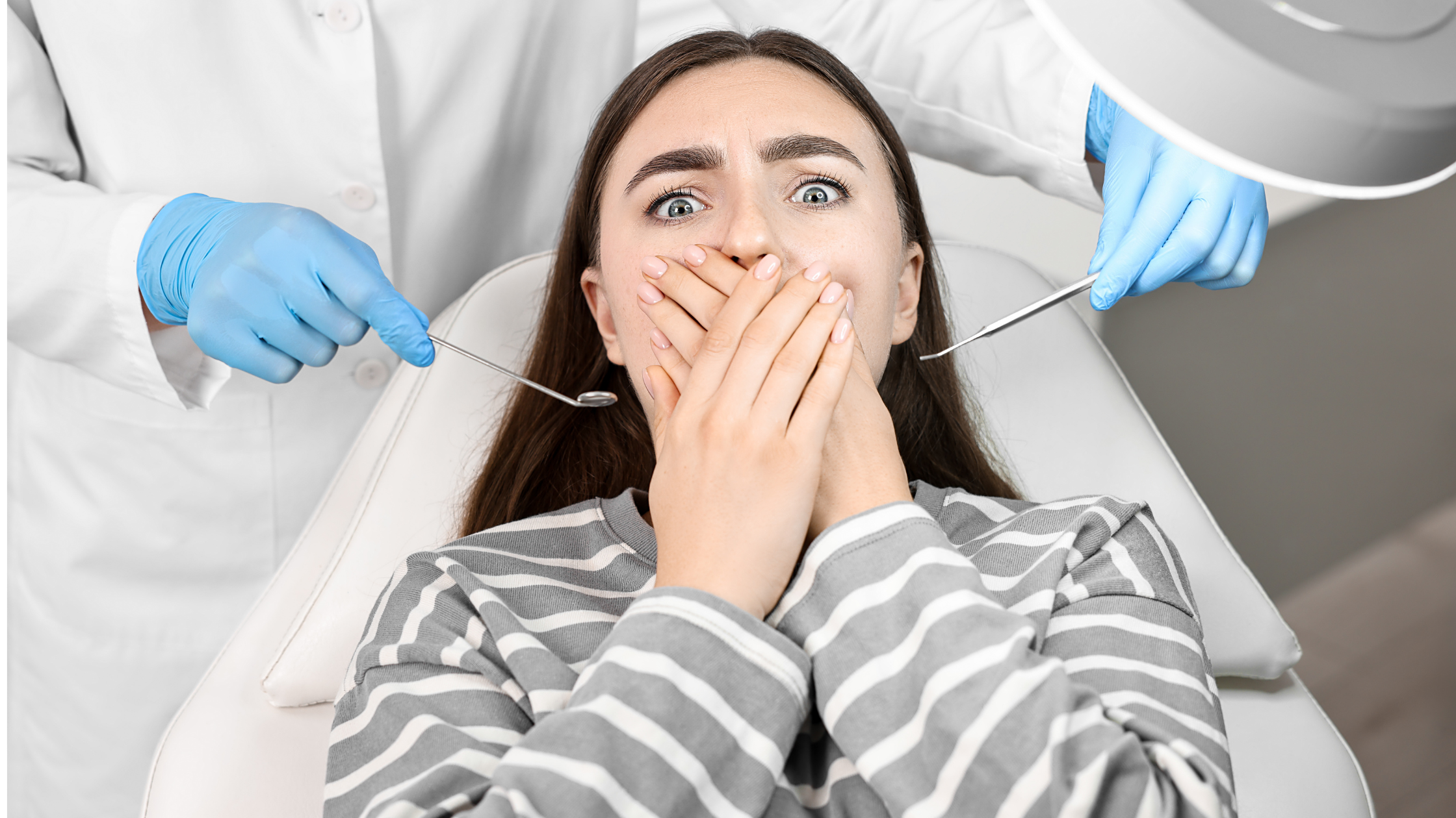 Nervous woman covering mouth at dentist with dental tools