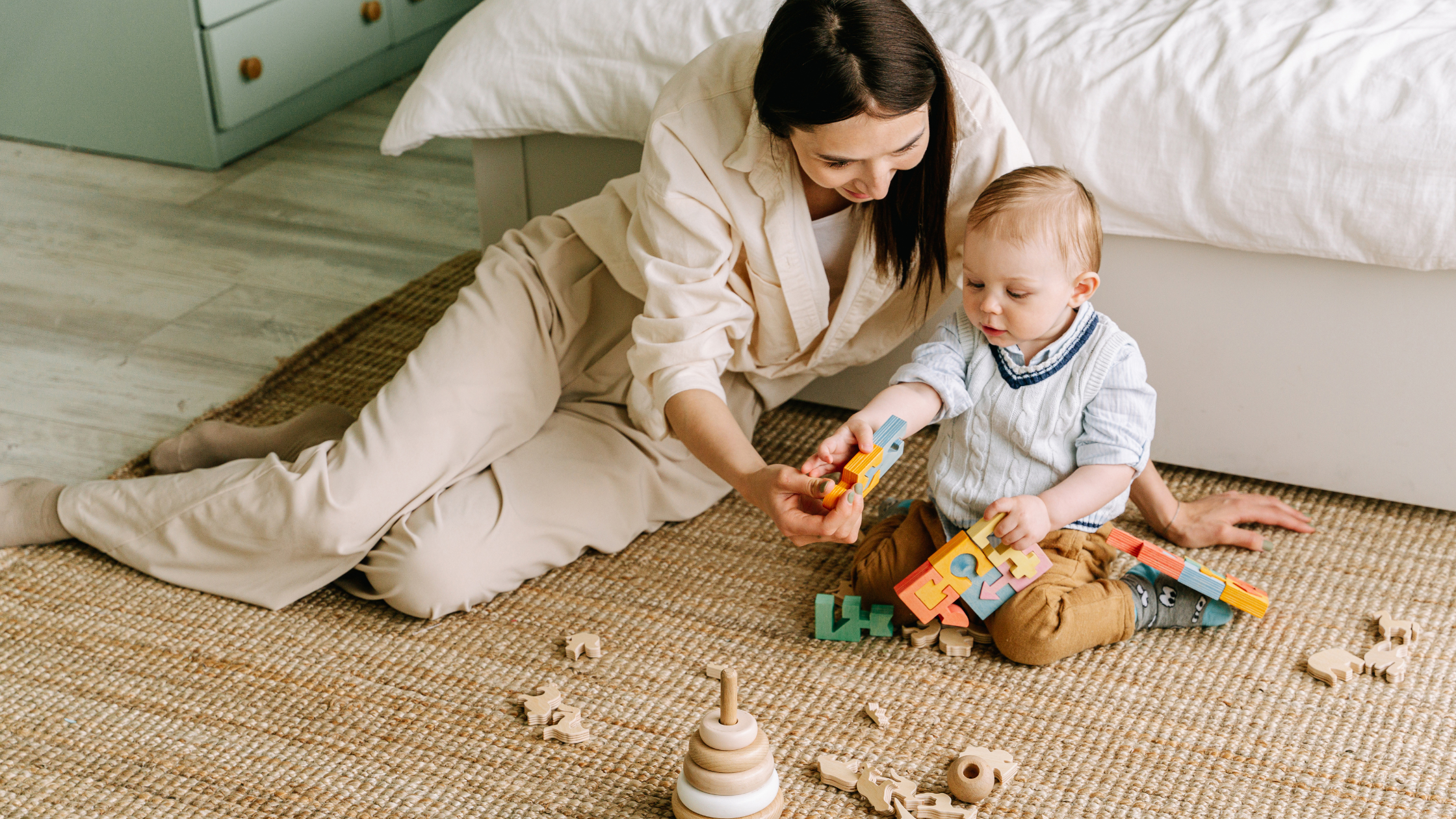Woman playing with toddler on floor using wooden puzzles