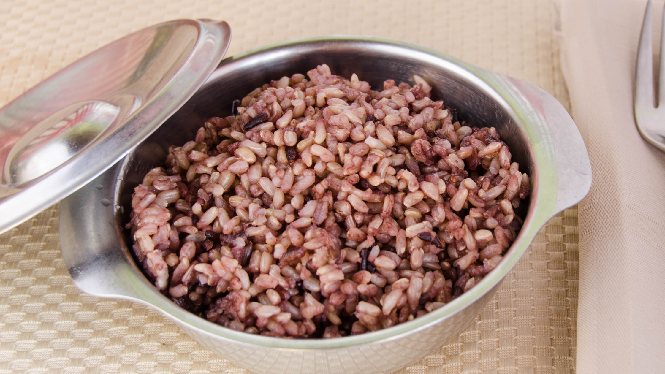 Cooked mixed brown and black rice in a metal bowl