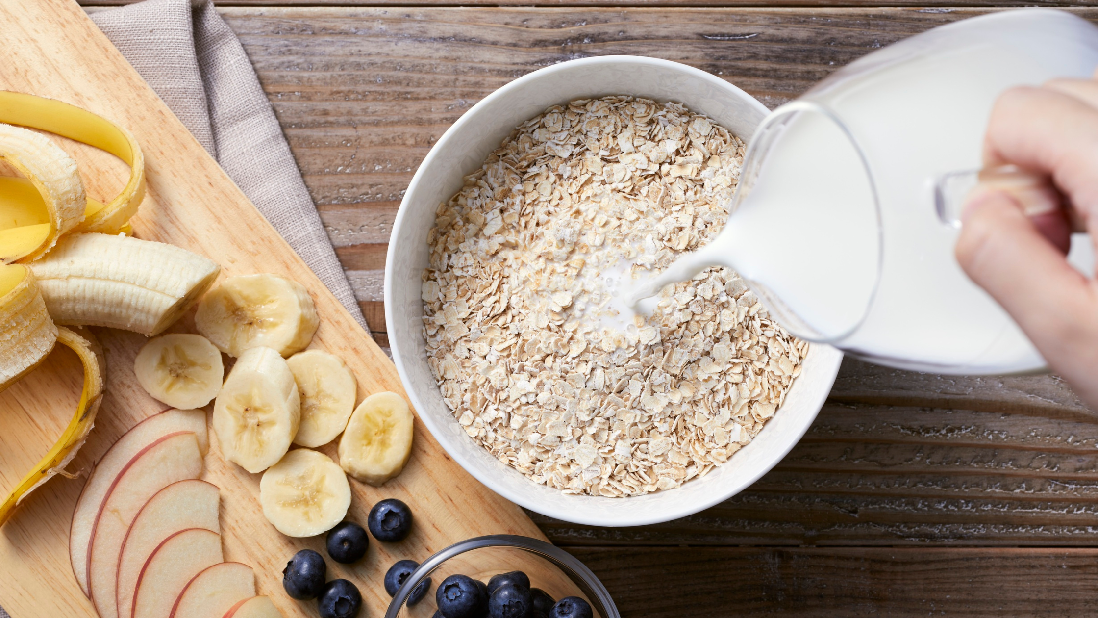 Milk poured over oats with sliced banana, apple, and blueberries
