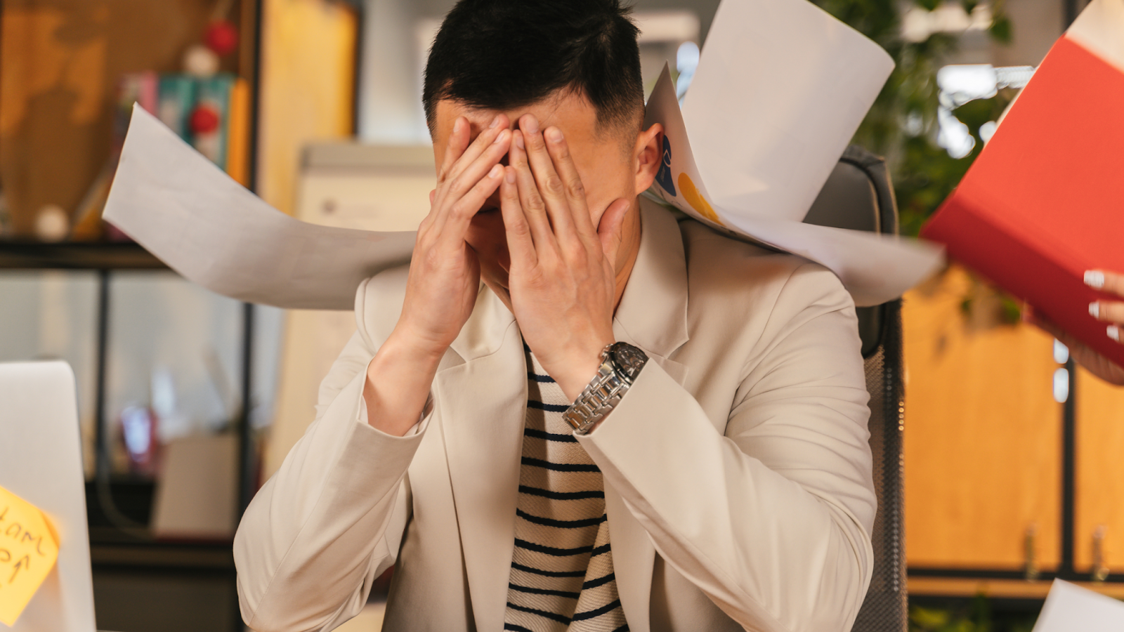 Stressed man covering face with hands at desk
