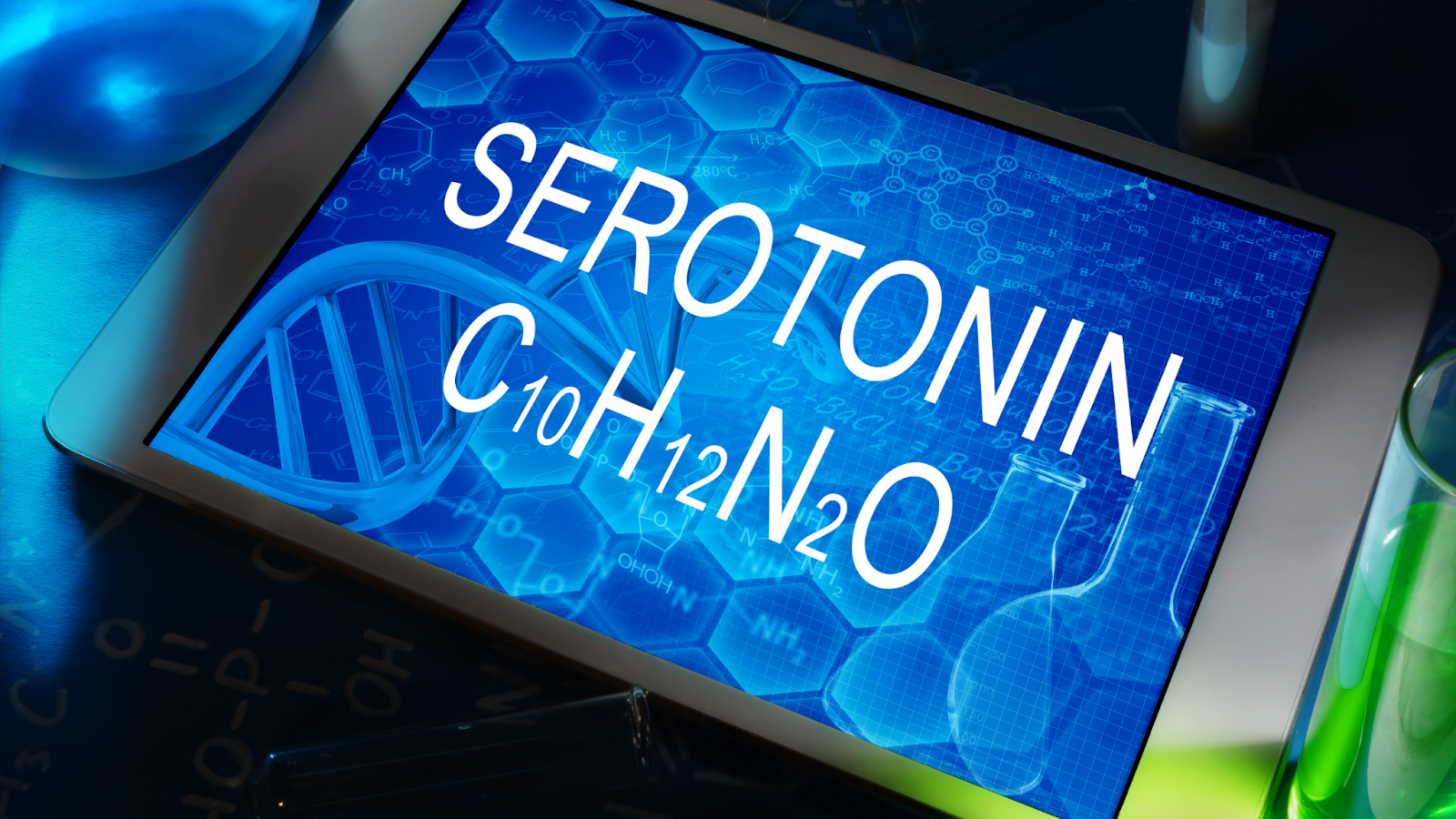 Tablet displaying serotonin chemical formula and DNA strand illustration