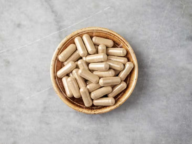 Bowl filled with beige ashwagandha supplement capsules
