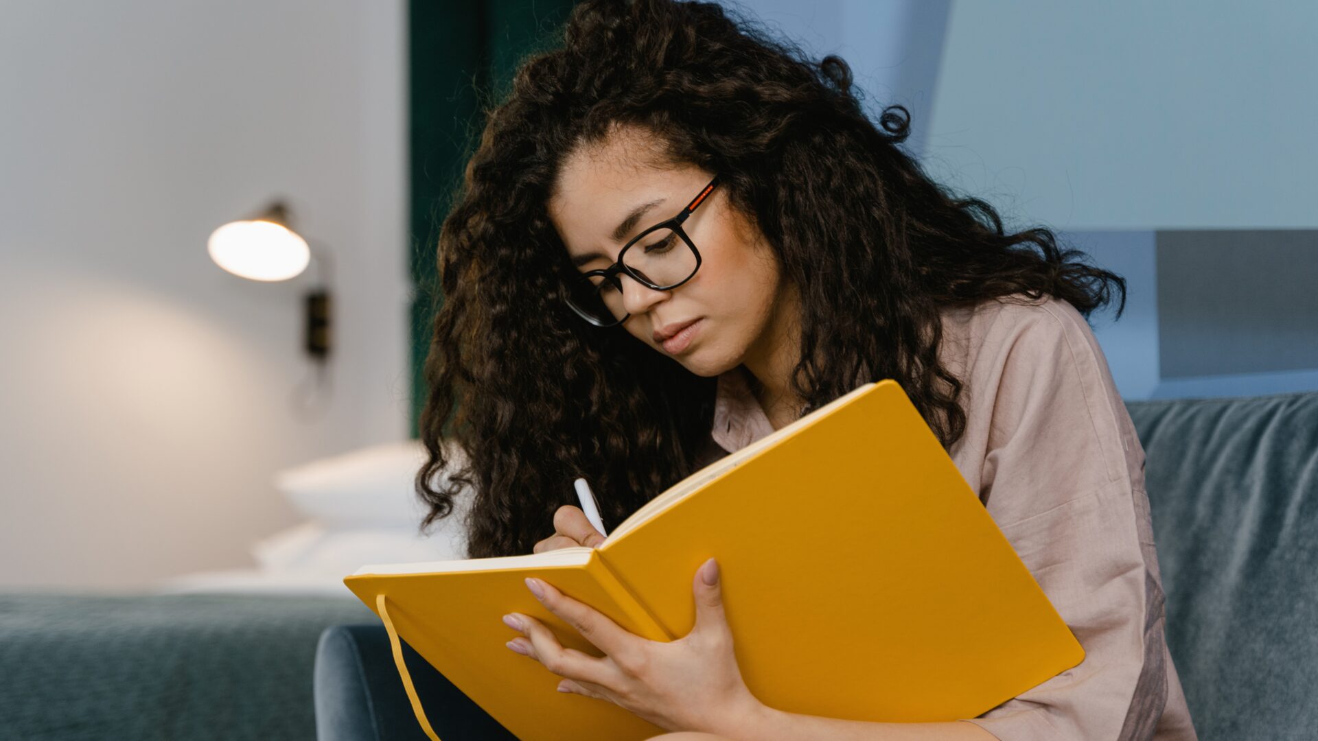 A person practicing cognitive behavioral therapy exercises for anxiety, writing thoughts in a journal and using deep breathing techniques for stress relief.