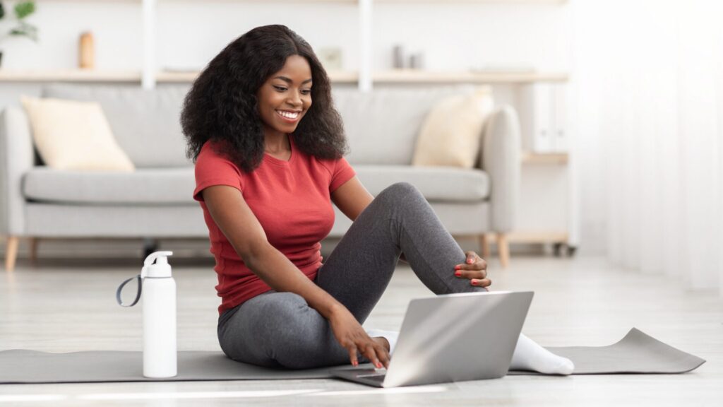 A person performs a 30-minute home exercise routine, including bodyweight squats, lunges, push-ups, and jumping jacks on a yoga mat in a living room.