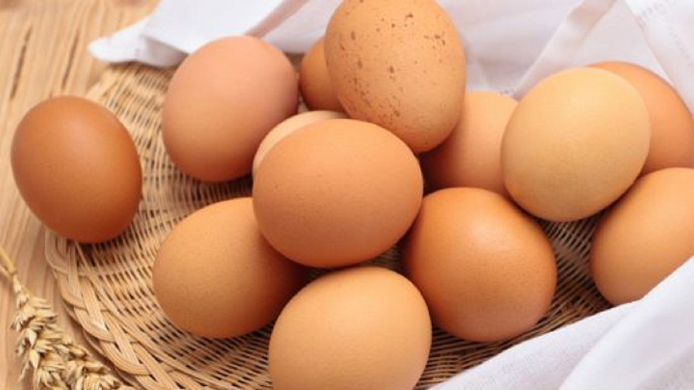 Brown eggs in a woven basket with white cloth