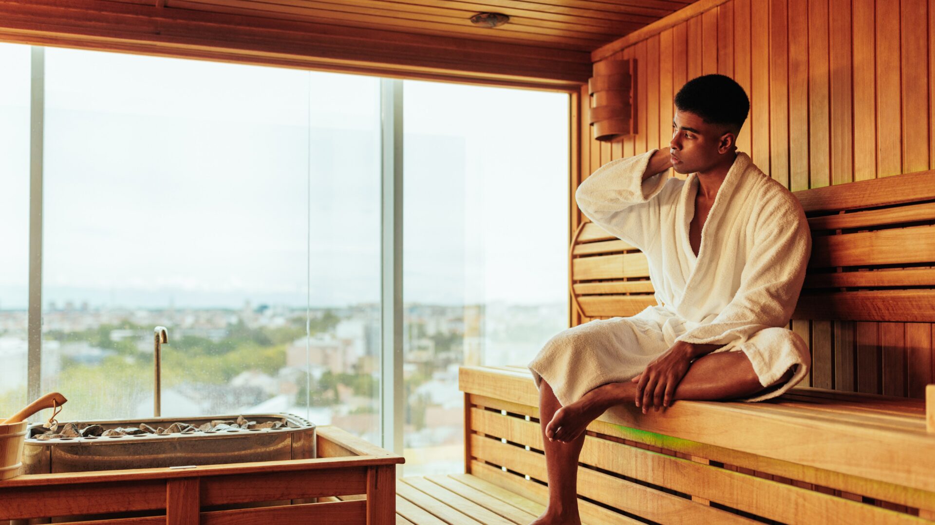 Person relaxing in a sauna after a workout, highlighting benefits like muscle recovery, reduced soreness, improved circulation, and relaxation.