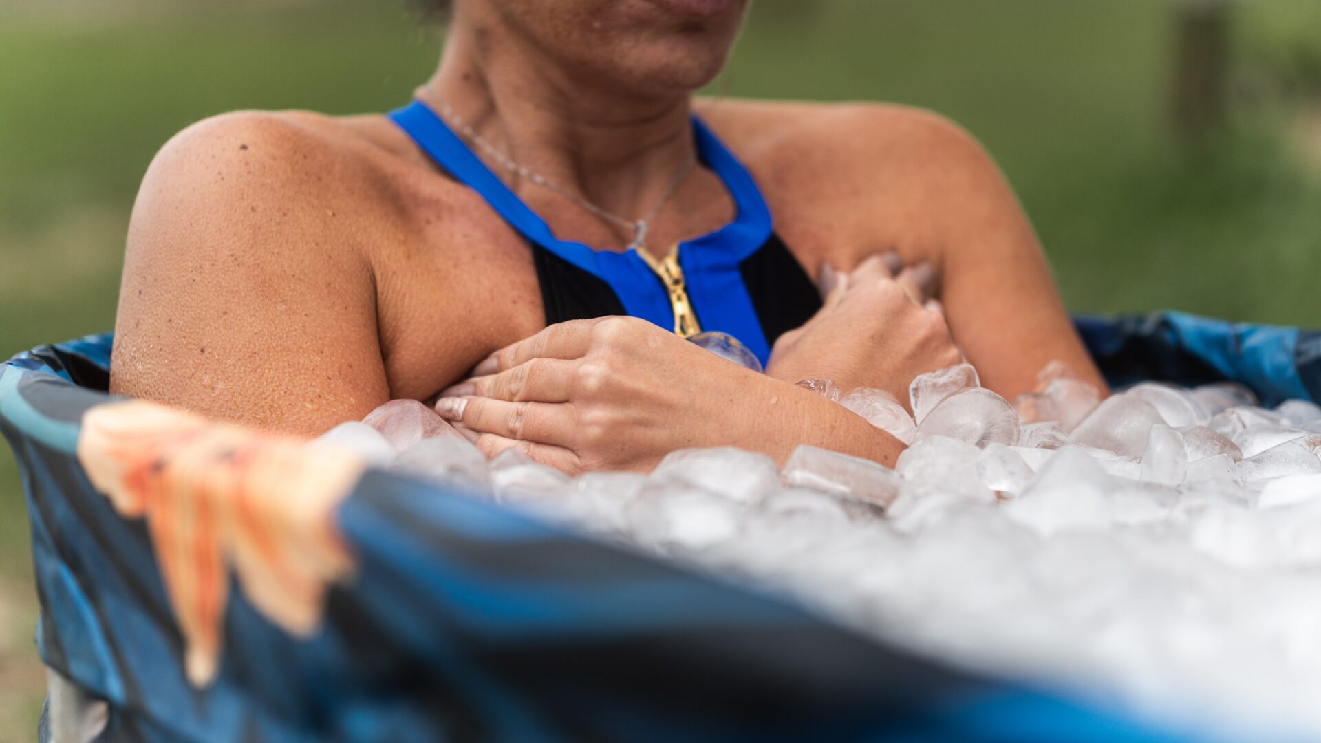Person immersing in a cold plunge tub, highlighting benefits like reduced muscle soreness, improved circulation, and enhanced mental clarity.