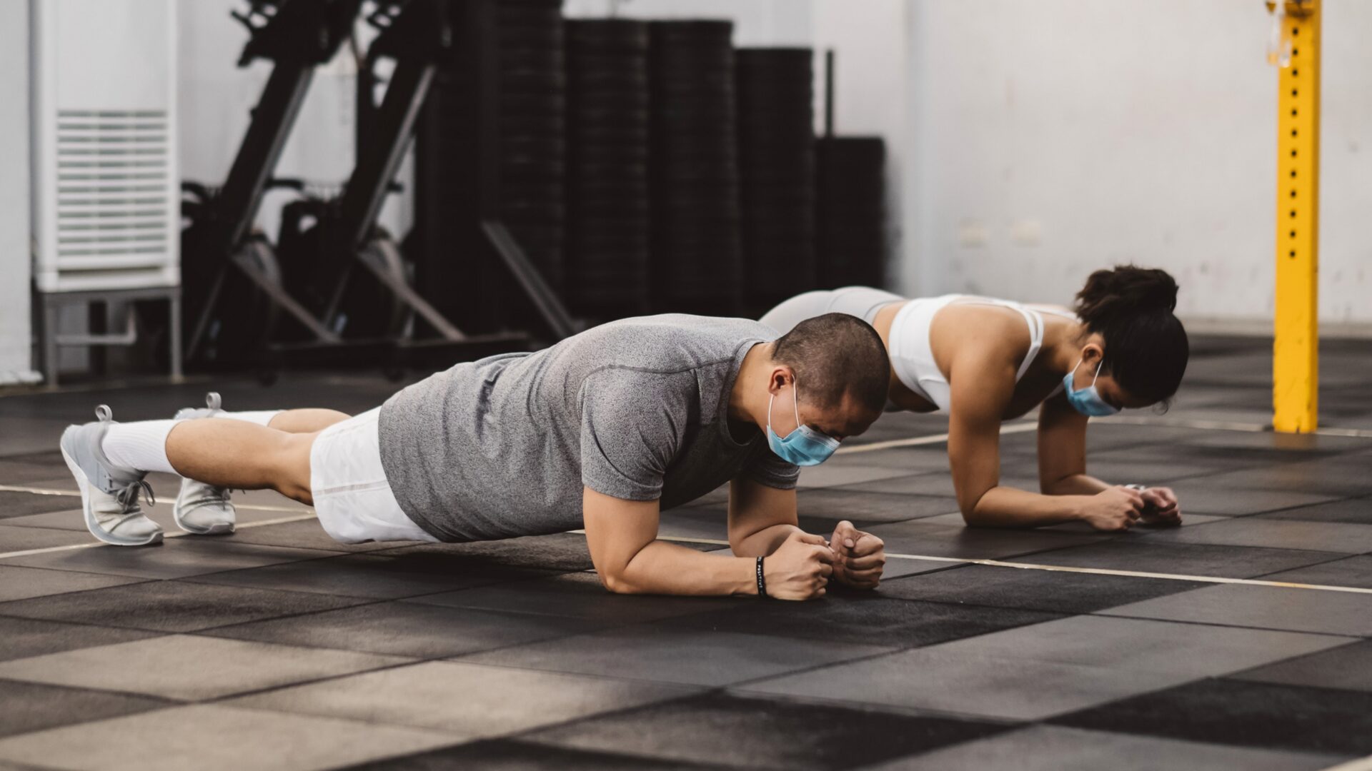 A beginner following workout tips, performing basic exercises with proper form in a gym setting, focusing on safe and effective fitness routines.