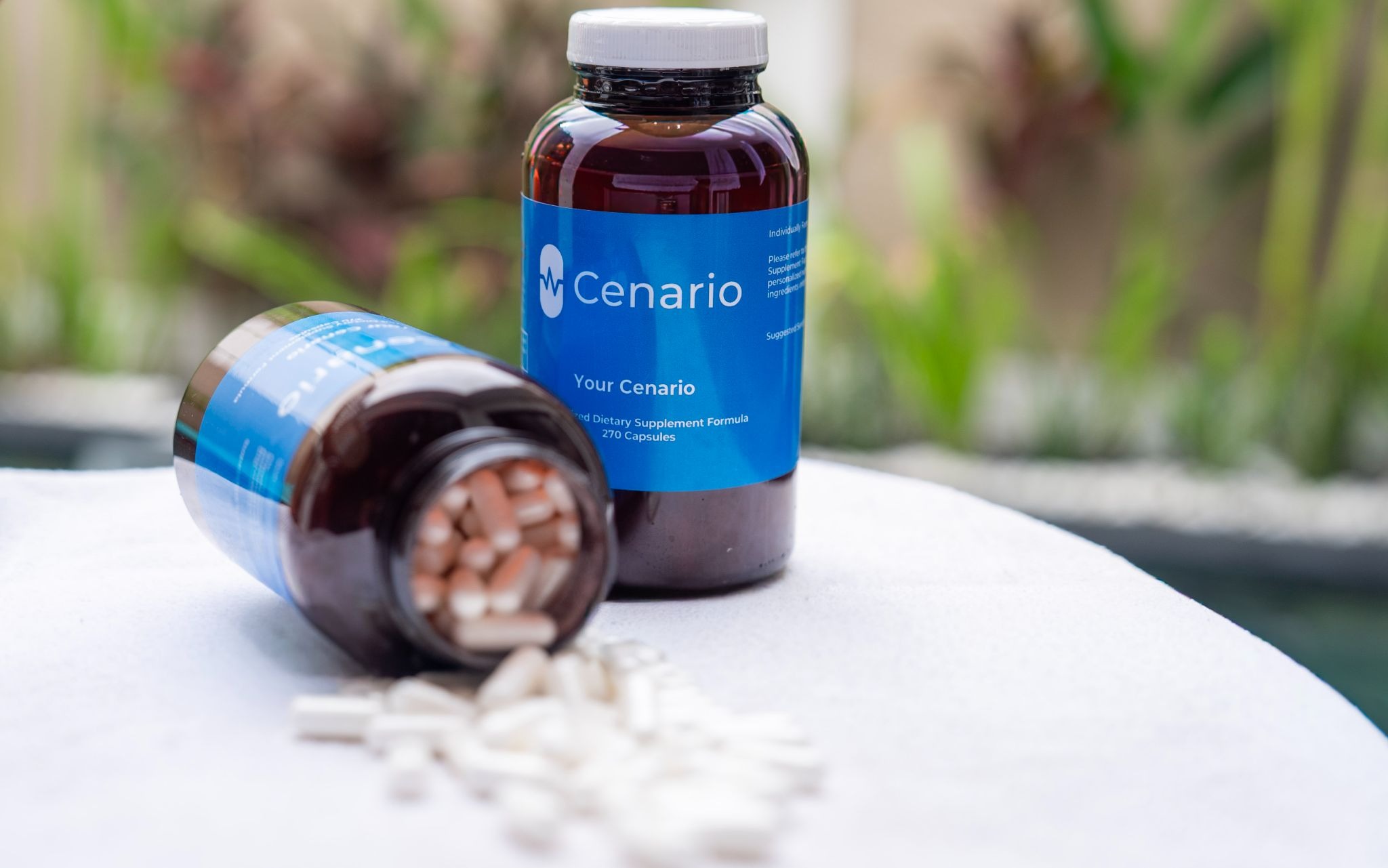 Two bottles of Cenario dietary supplements with capsules spilled out