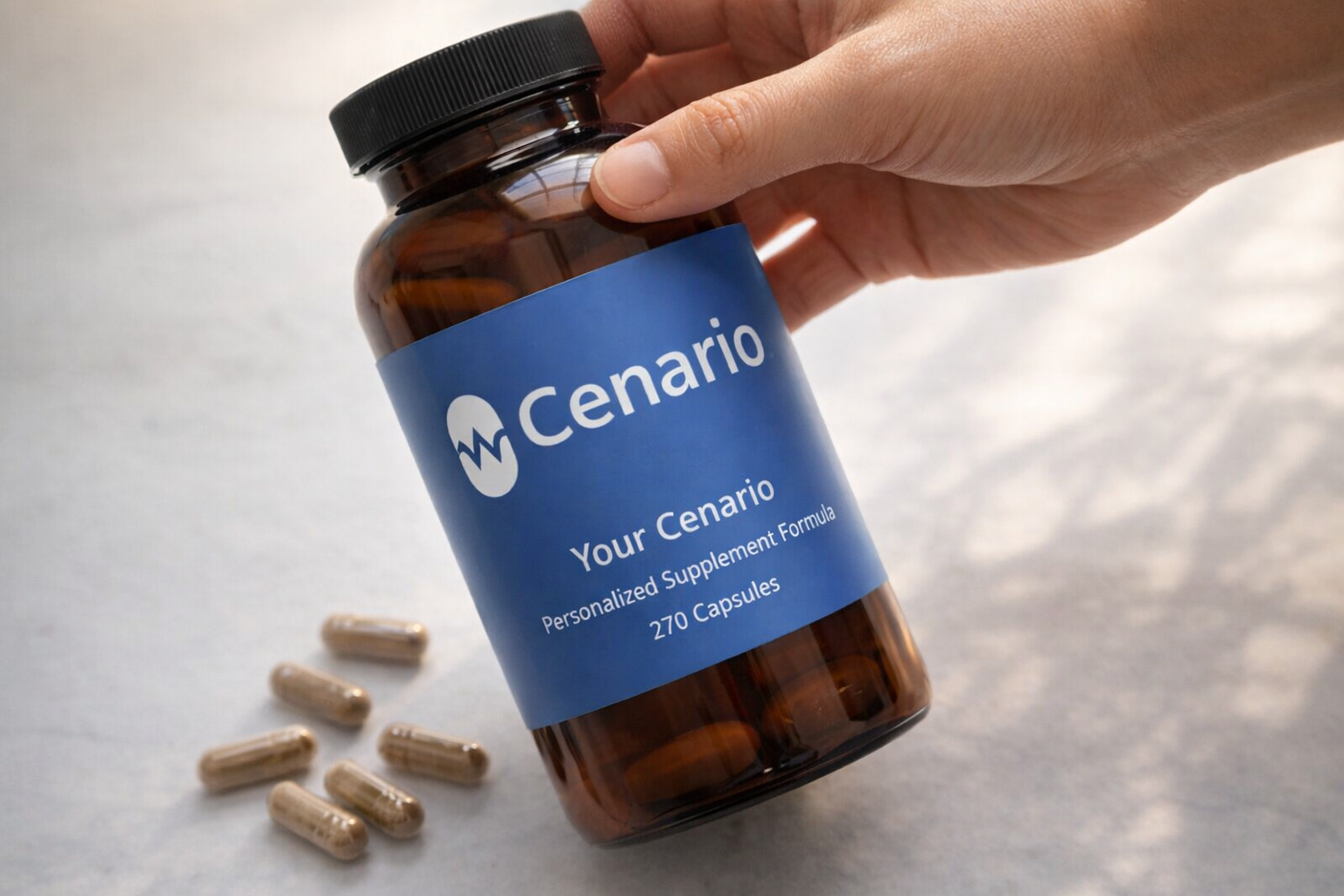 Hand holding a bottle of Cenario supplement capsules