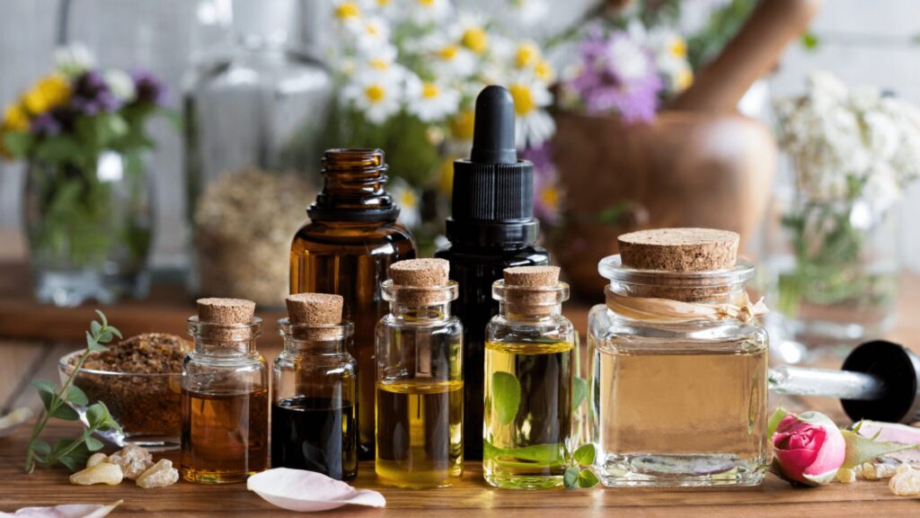 A selection of essential oil blends for anxiety, featuring bottles of lavender, chamomile, and bergamot oils with fresh herbs on a calming wooden surface.