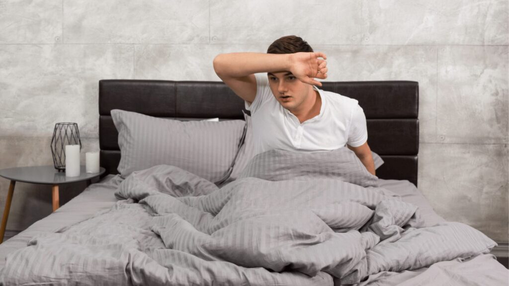 A child experiencing a night terror, sitting up in bed with a frightened expression, unaware of surroundings, during a deep sleep episode at night.