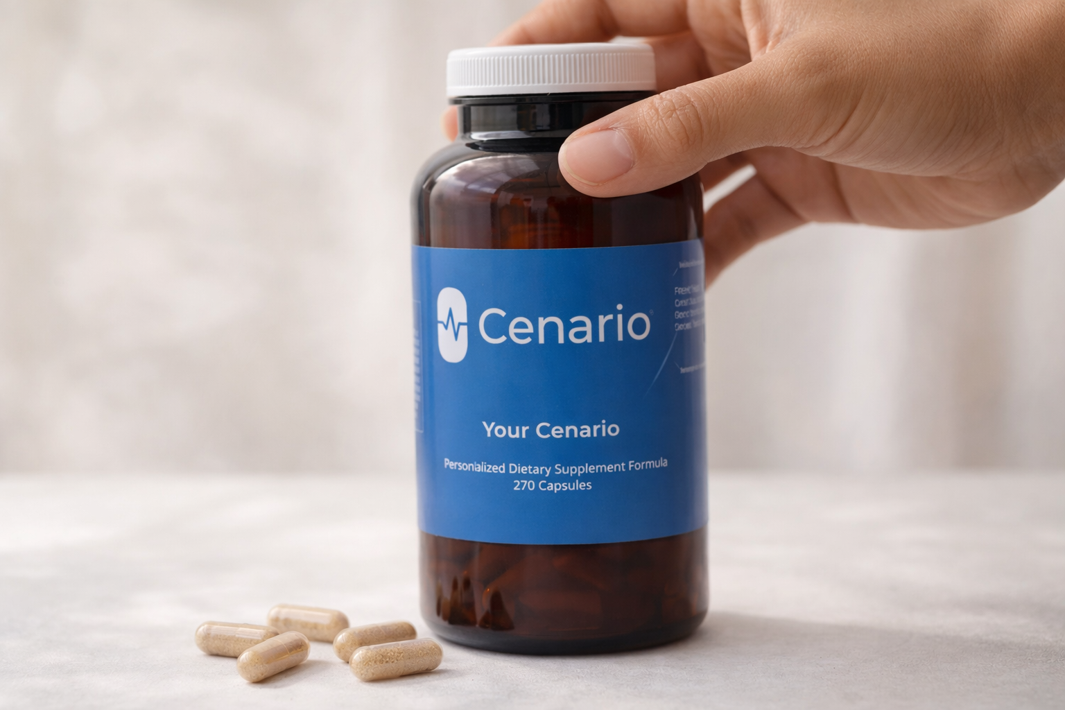 Hand holding Cenario dietary supplement bottle with capsules