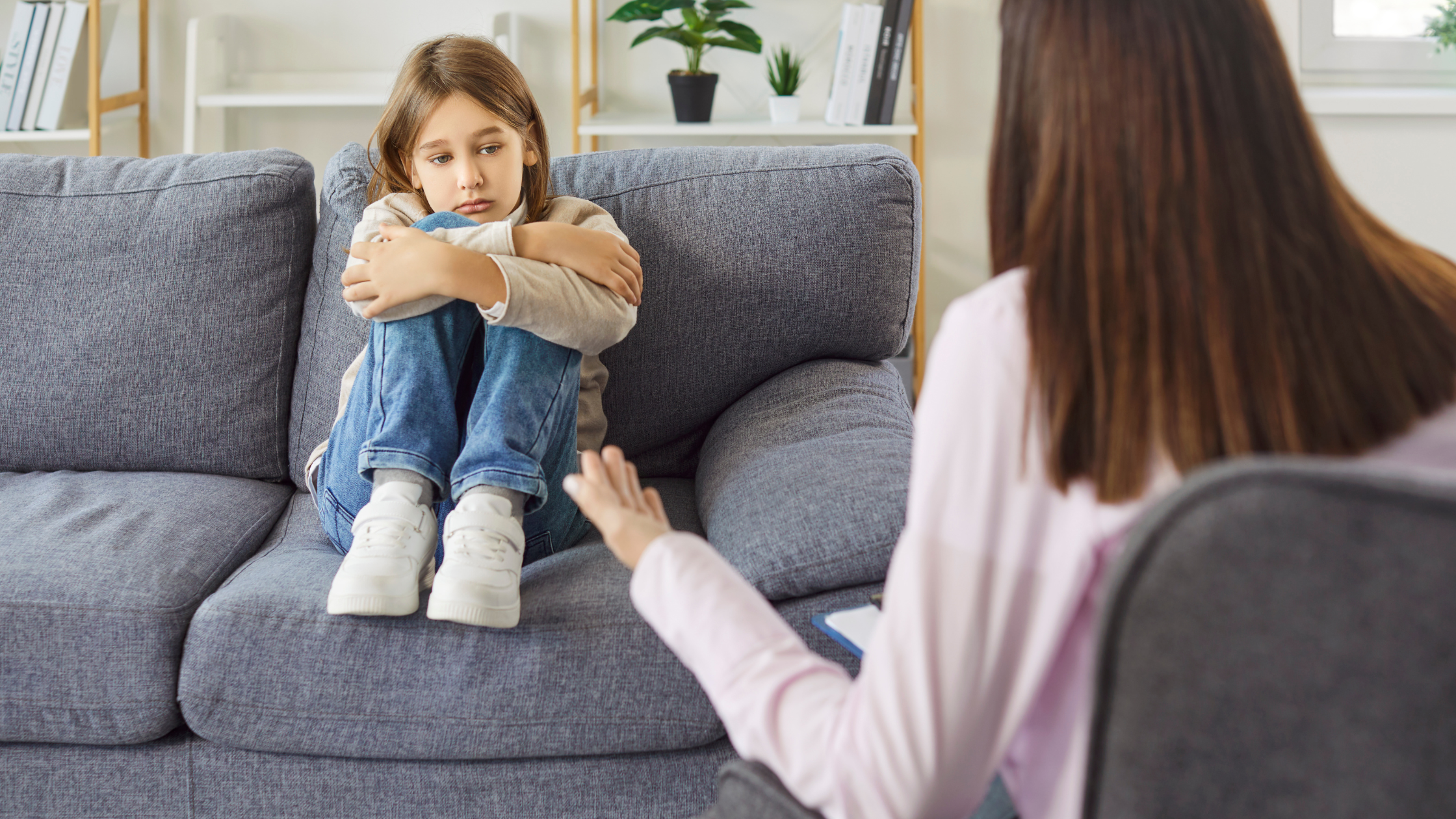 Young girl sitting on couch talking with therapist