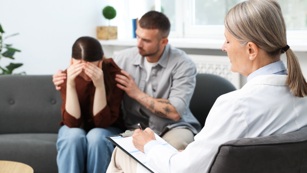 A therapist guides a couple through emotionally focused therapy, helping them express feelings and strengthen their emotional connection in a supportive setting.