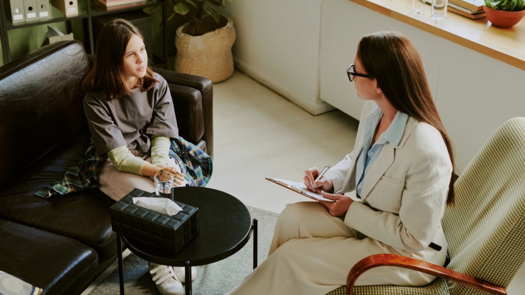 A person searching online for how to find a therapist, reviewing therapist profiles and contact information on a laptop in a comfortable home setting.