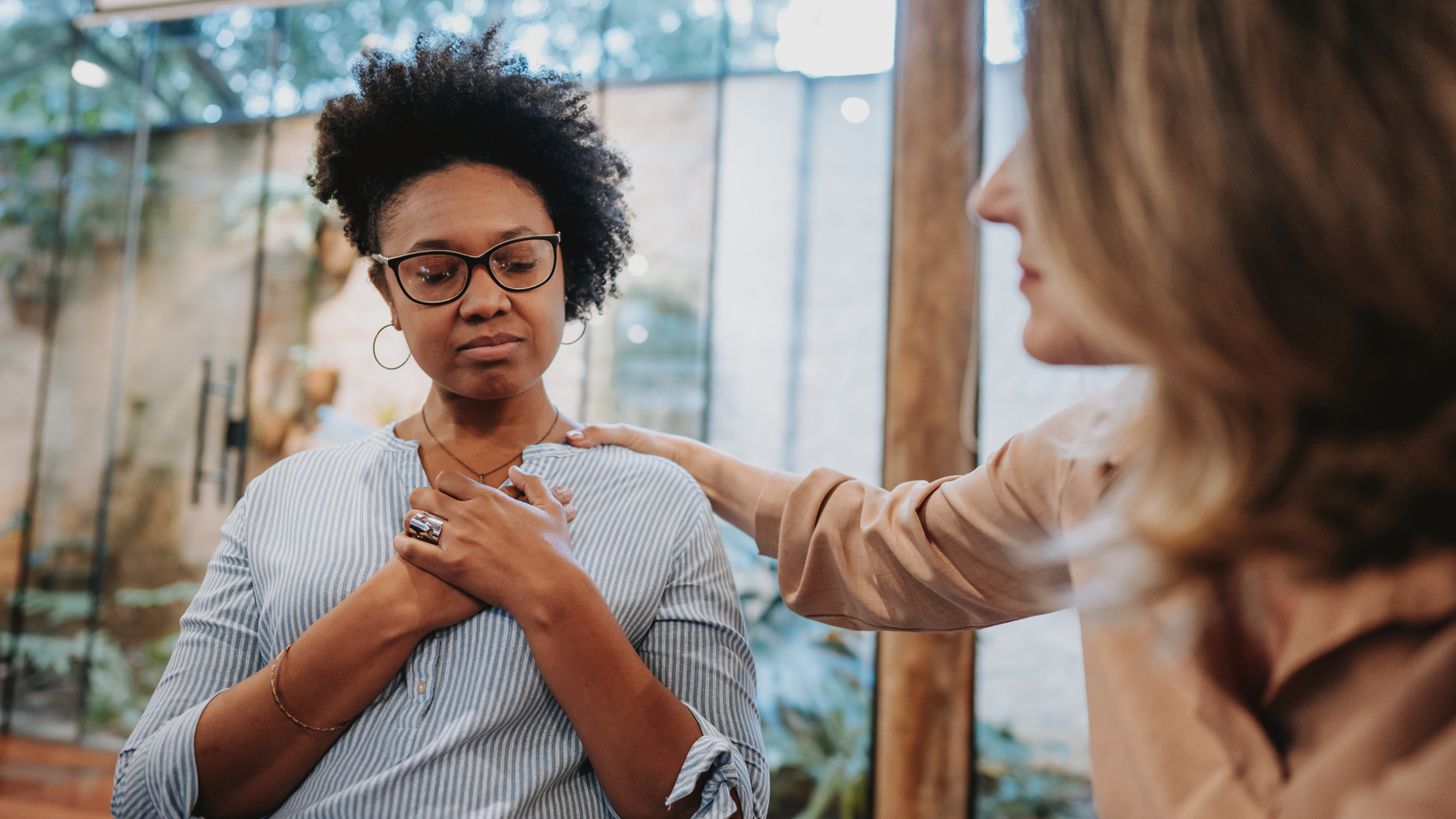 A therapist and client sit facing each other in a calm, welcoming office, engaging in open dialogue as part of a humanistic therapy session.