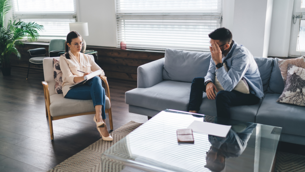 A therapist and client sit facing each other in a calm setting, engaging in open, empathetic conversation, illustrating person centered therapy.