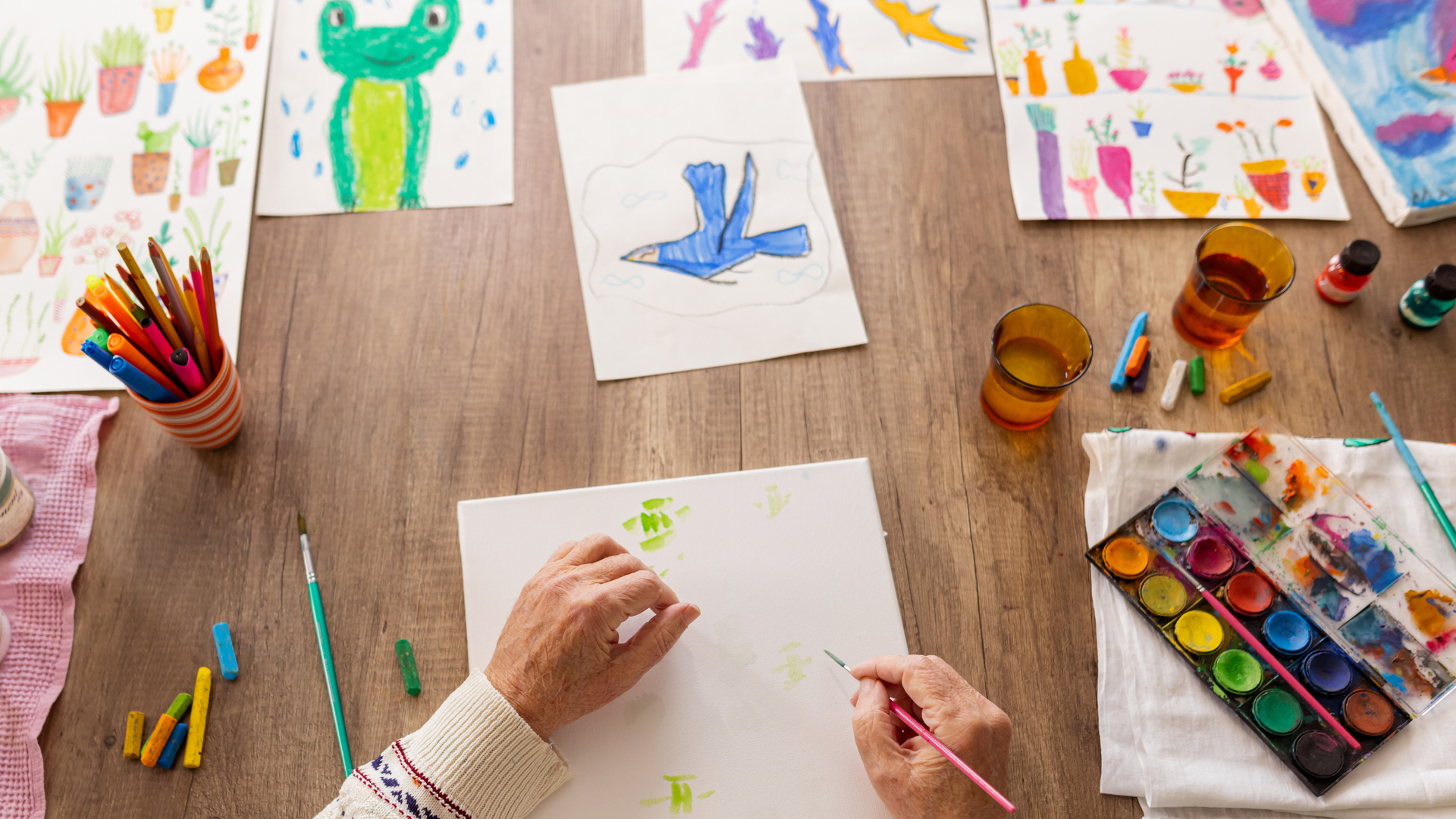 A person creates a colorful painting during an art therapy session, using art materials to express emotions and support mental health and self-discovery.
