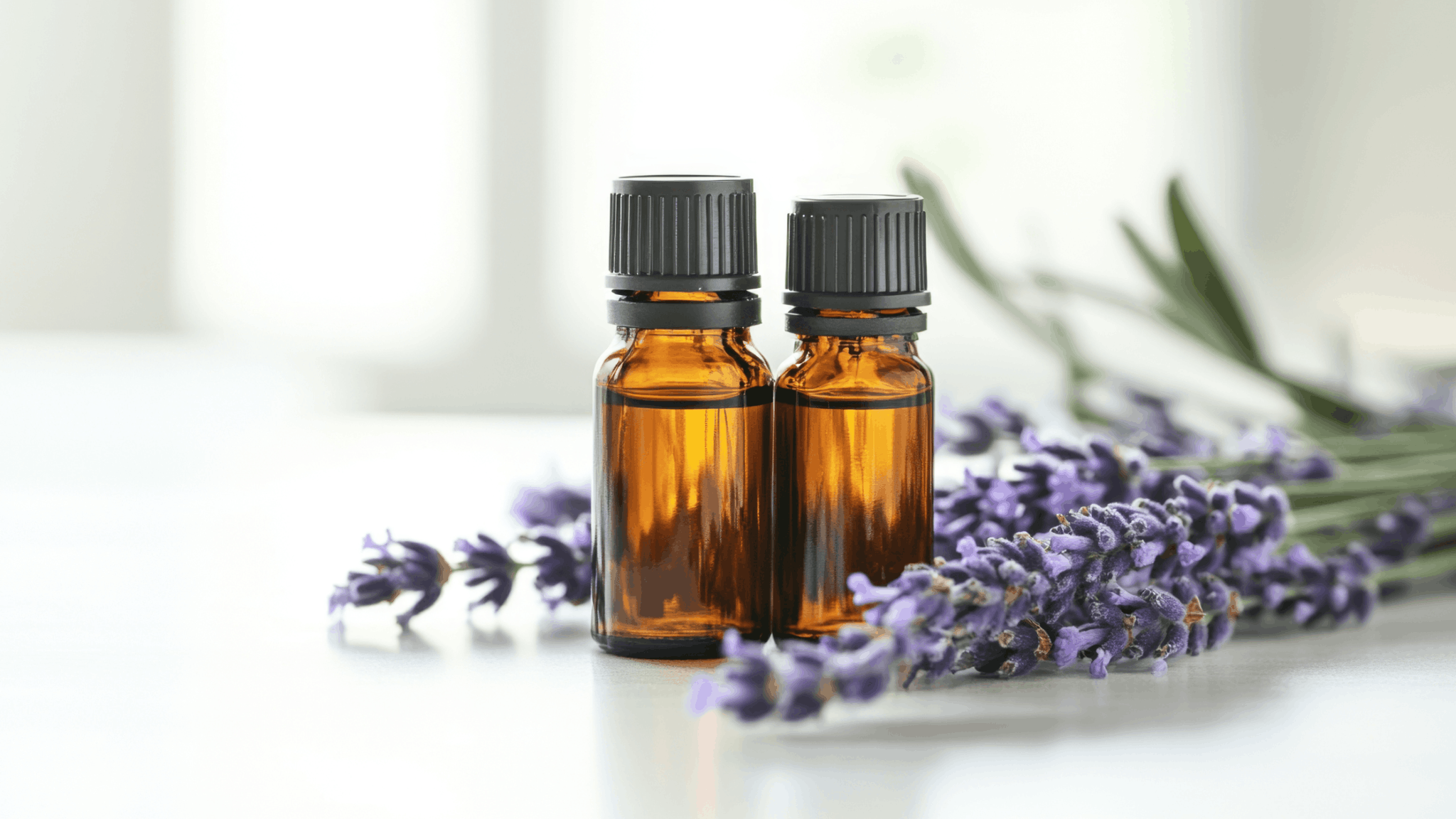 Two amber essential oil bottles with lavender sprigs