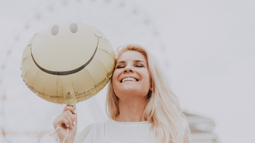 A smiling person enjoys a peaceful walk in nature, practicing mindfulness and gratitude as part of their journey to become a happier, more fulfilled individual.
