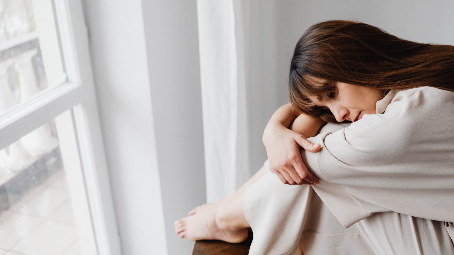 A person sits quietly with eyes closed, practicing mindfulness meditation to cope with emotional pain and promote inner healing and self-care.