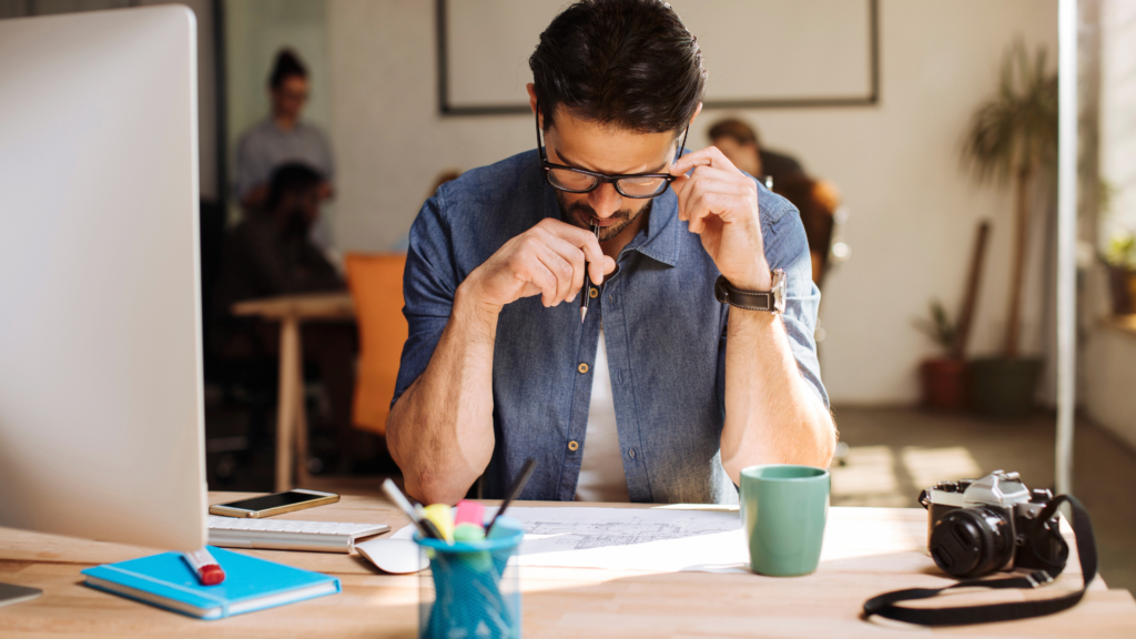 A person practicing mindfulness meditation at a desk with a notebook and water bottle, illustrating techniques to improve focus and concentration.