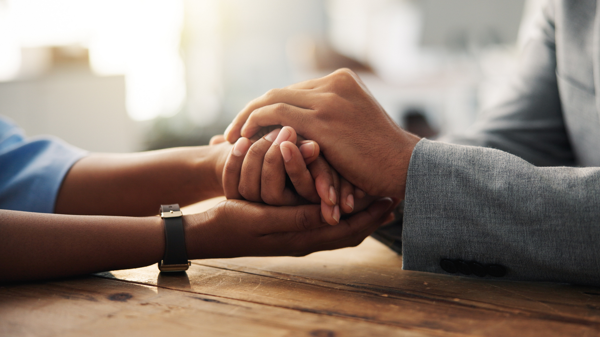 Two people sit facing each other, one listening attentively with a gentle expression, demonstrating empathetic understanding through body language and eye contact.