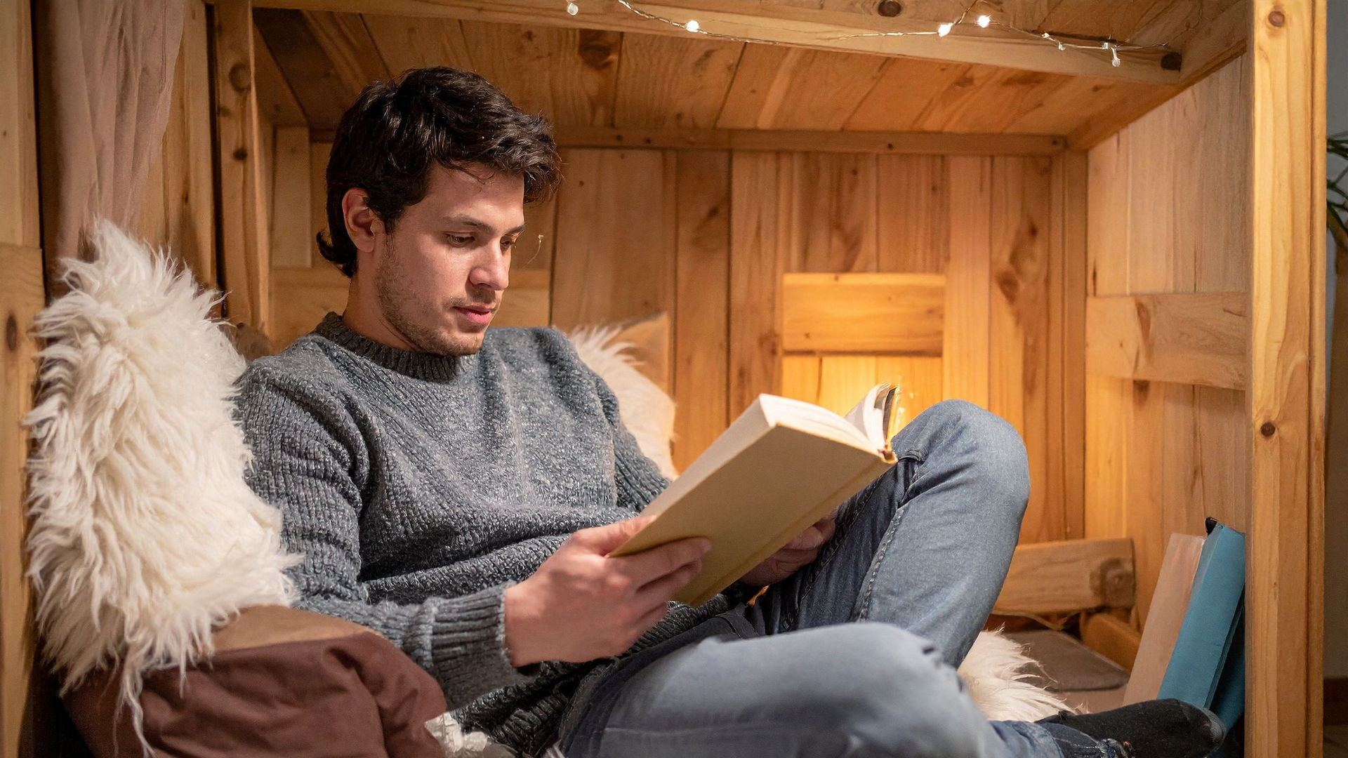 A person highlights text and takes notes in a book, using sticky tabs and a notebook to help remember and review what they read.
