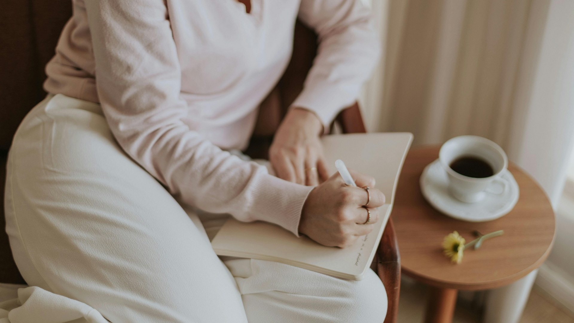 A notebook open to a blank page with a pen beside it, ready for someone to write therapy-focused journaling prompts for self-reflection and emotional growth.