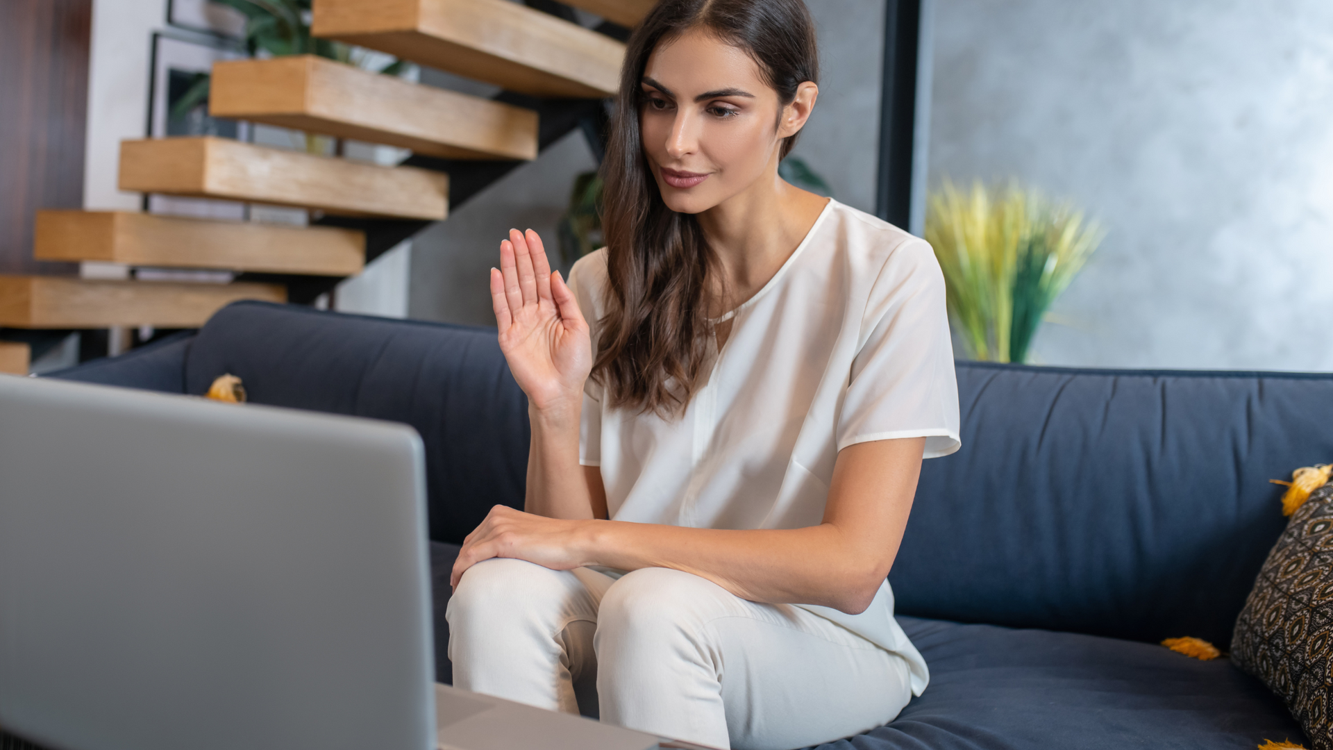 A person participating in an online therapy session for depression, communicating with a mental health professional via video call on a laptop at home.