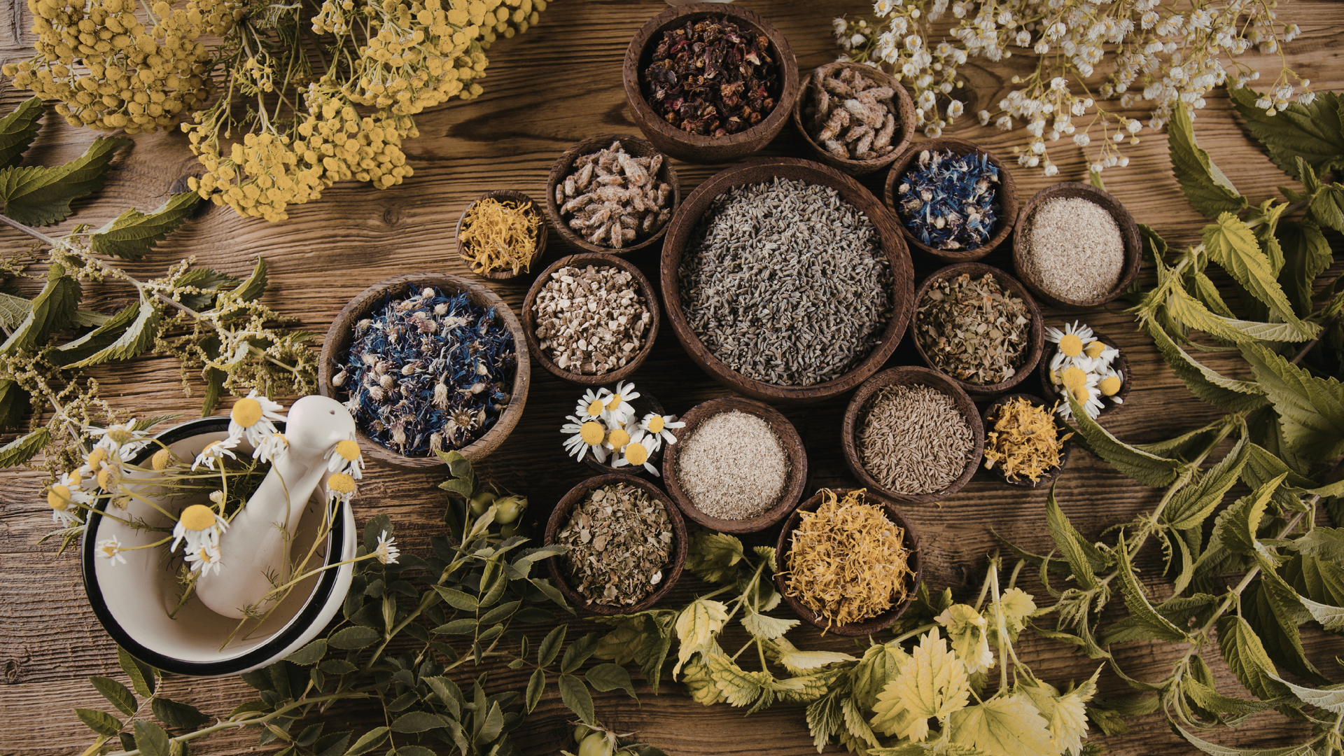 Assorted herbal remedies including dried herbs, tinctures, and herbal teas arranged on a wooden table, highlighting natural alternative medicine options.