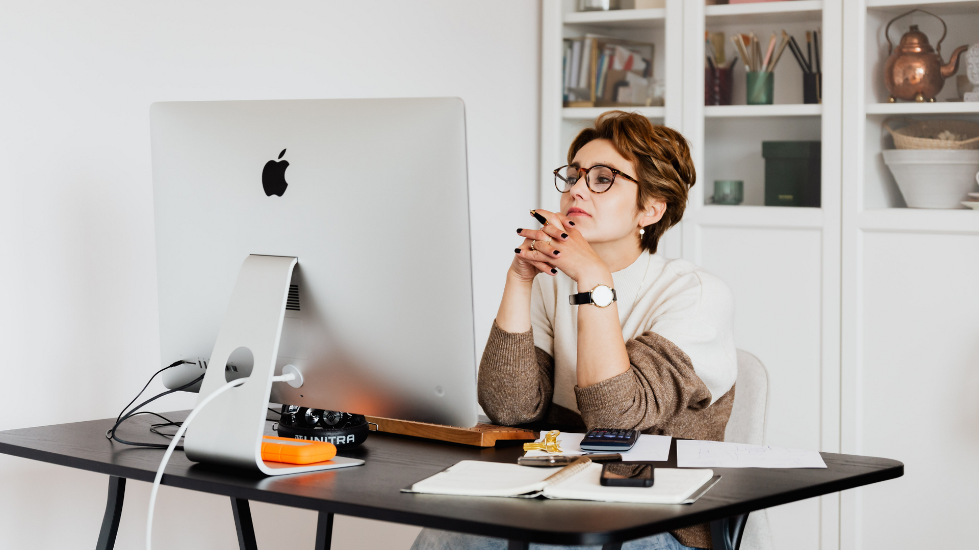 A person sitting at a desk with a laptop, appearing distracted, then refocusing on work, illustrating the time it takes to regain concentration after interruption.
