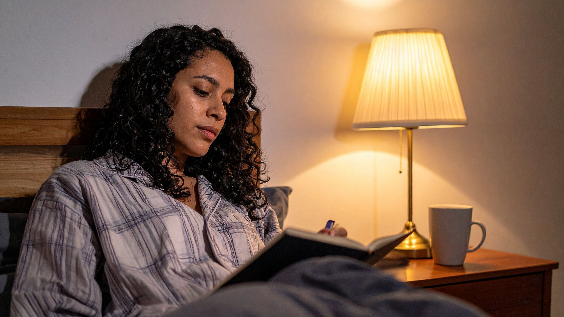 A person practices sleep hygiene by turning off electronic devices, dimming lights, and preparing a comfortable bed for a restful night’s sleep.
